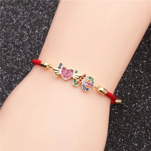 Detail of red woven bracelet with gold LOVE charm and multi-color pavé zircon stones