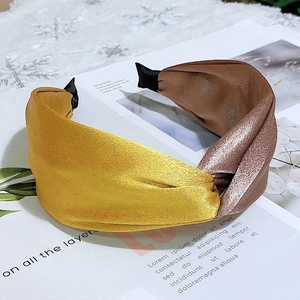 Detail of wide satin headband with yellow and brown twist knot on magazine page