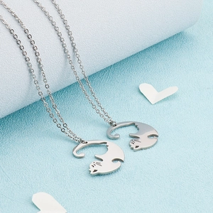 Détail des pendentifs chat en acier inoxydable argenté sur fond bleu texturé