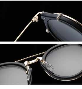 Macro view of gold-trimmed metal sunglasses showing durable hinges and clear nose pads
