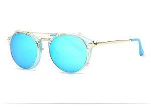 Detail of round metal sunglasses with blue lenses and engraved golden vintage temples