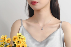 Close-up of S925 silver necklace with 1 carat moissanite pendant on a model's neck