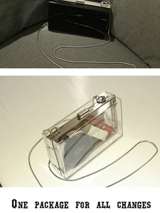Detail view of acrylic box clutch showing storage capacity for cosmetics and metal snake chain