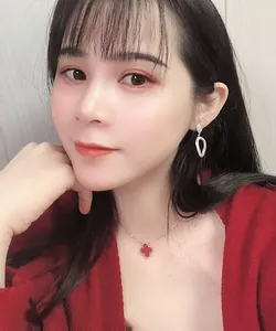 Close-up of red clover pendant necklace and sparkling teardrop earrings on model