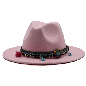 Detailed view of pink fedora with bohemian woven band, metal studs, and colorful tassels