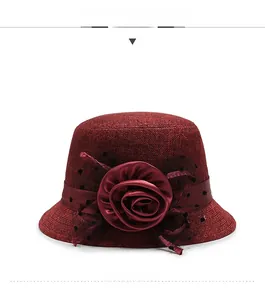 Close-up of elegant burgundy linen hat with mesh polka dot flower and woven texture