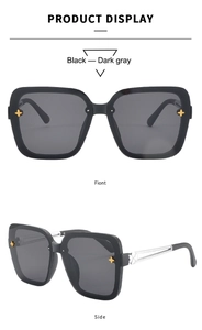 Detail view of black square sunglasses with gold star accents and silver hollowed temples