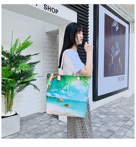 Detail of canvas tote bag with tropical island print and sturdy rope handle on shoulder