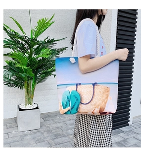 Detail of canvas beach tote bag featuring thick rope handles and summer beach print