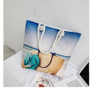Detail of beach tote bag featuring thick rope handles and coastal aesthetic prints