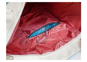 Internal view showing dark red fabric lining and a secure zipper pocket for essentials