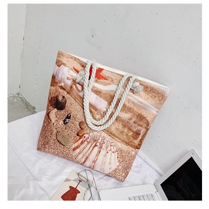 Detail of beach tote bag featuring sea shell print and nautical rope handle design