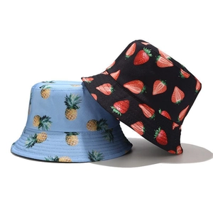 Close-up of fruit print bucket hats featuring pineapple and strawberry patterns