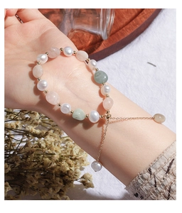Detail of natural freshwater pearl bracelet with green and pink gemstones on wrist