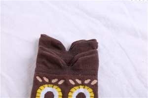 Close-up of brown cotton socks with cartoon owl face pattern and V-notch cuff design