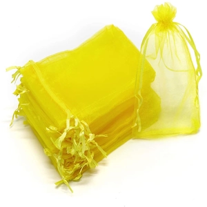 Detail of yellow organza gift bags with gold stamping and satin drawstring closure