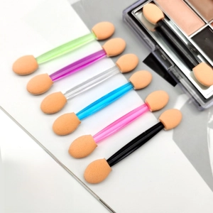 Close-up of double-ended sponge eyeshadow applicators with colorful translucent handles