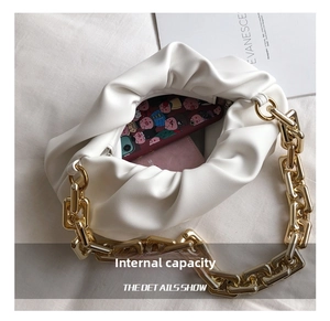 Interior view of white pleated cloud bag with gold chain showing phone and wallet capacity