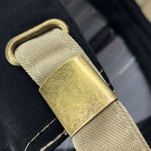 Macro shot of adjustable brass buckle on khaki canvas baseball cap strap