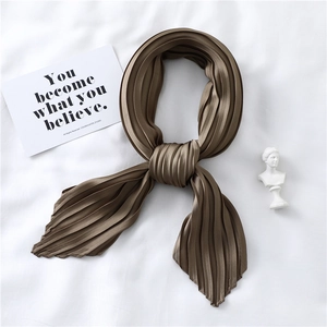 Detailed view of bronze pleated satin scarf with elegant crinkle texture and silky finish