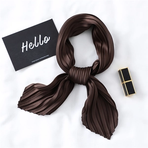 Detailed close-up of dark brown pleated silk scarf with satin finish and accordion folds