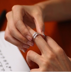 Detail shot of hands-hug design 925 silver plated ring with high-polish finish