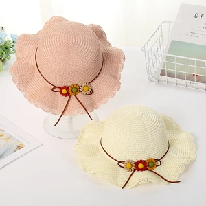 Close-up of woven straw sun hat featuring knitted floral accents and wavy brim detail