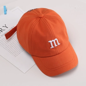 Kids orange cotton baseball cap with M embroidery and cartoon eyes on a white background
