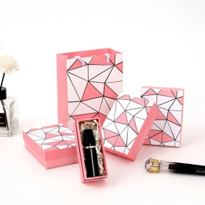 Detailed view of pink geometric jewelry boxes and matching gift bags for accessories