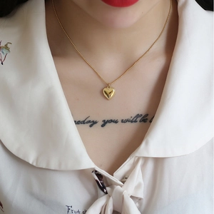 Elegant 18K gold-plated heart pendant necklace with delicate beaded chain on a model