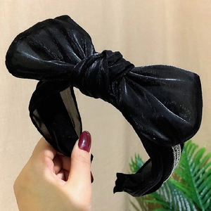 Close-up of black velvet headband with polka dot mesh, rhinestones and knotted bow