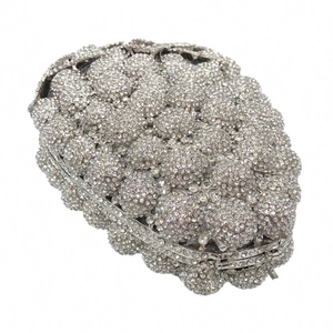 Close-up of silver grape-shaped crystal evening clutch with hollow out rhinestones