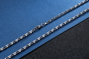 Macro view of silver box chain necklace with lobster clasp in polished stainless steel