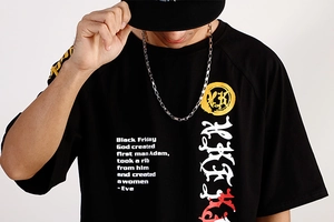 Detail of hip-hop chain necklace with calligraphy pattern on black round neck shirt