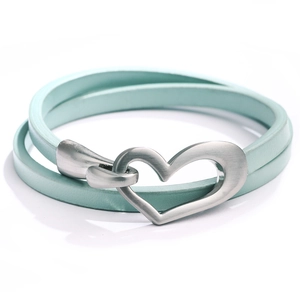 Détail du bracelet en cuir vert menthe avec un fermoir en forme de cœur argent brossé
