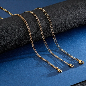 Three gold stainless steel curb link necklaces with lobster clasps on textured background