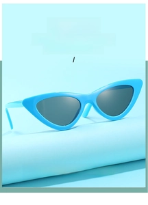 Nahaufnahme der hellblauen Cat-Eye-Sonnenbrille mit grauen Gläsern auf blauem Hintergrund