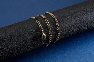 Close-up of golden titanium steel flat chain link necklace with lobster clasp on display