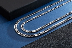 Close-up of silver stainless steel Cuban link chain with metallic luster and weave texture