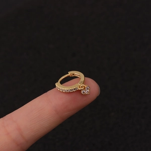 Detailed close-up of a gold heart charm earring featuring sparkling zircon stones and paving