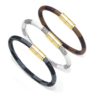 Détail de bracelets en cuir tressé à motif damier et fermoirs magnétiques dorés