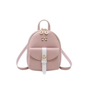 Pink mini PU leather backpack with gold bow accent and white strap pocket on white background