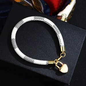 Bracelet à damier chic avec charm cadenas en forme de cœur doré sur boîte à bijoux