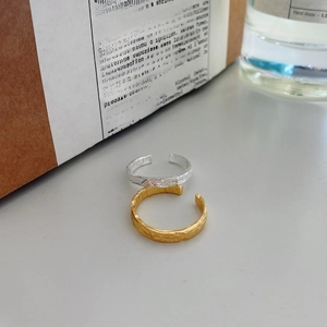 Detail of minimalist S925 sterling silver rings with hammered gold foil texture finish