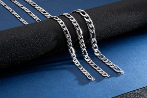 Three silver stainless steel link chains in different widths displayed on black stand