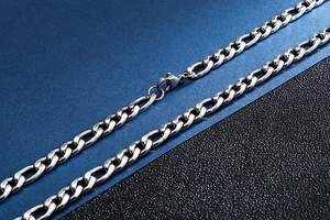 Detailed close-up of a silver stainless steel Figaro chain necklace with a lobster clasp