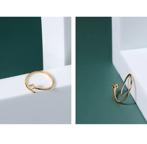 Close-up of a minimalist gold star ring featuring a sparkling zircon on a green background