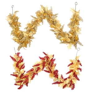 Christmas garland with gold leaves and red berries hanging on a plain white background