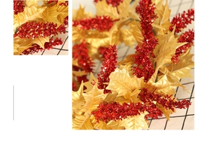 Detail of Christmas wreath with golden leaves and glittering red berry clusters