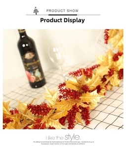 Close-up of Christmas garland with golden holly leaves and sparkling red berries